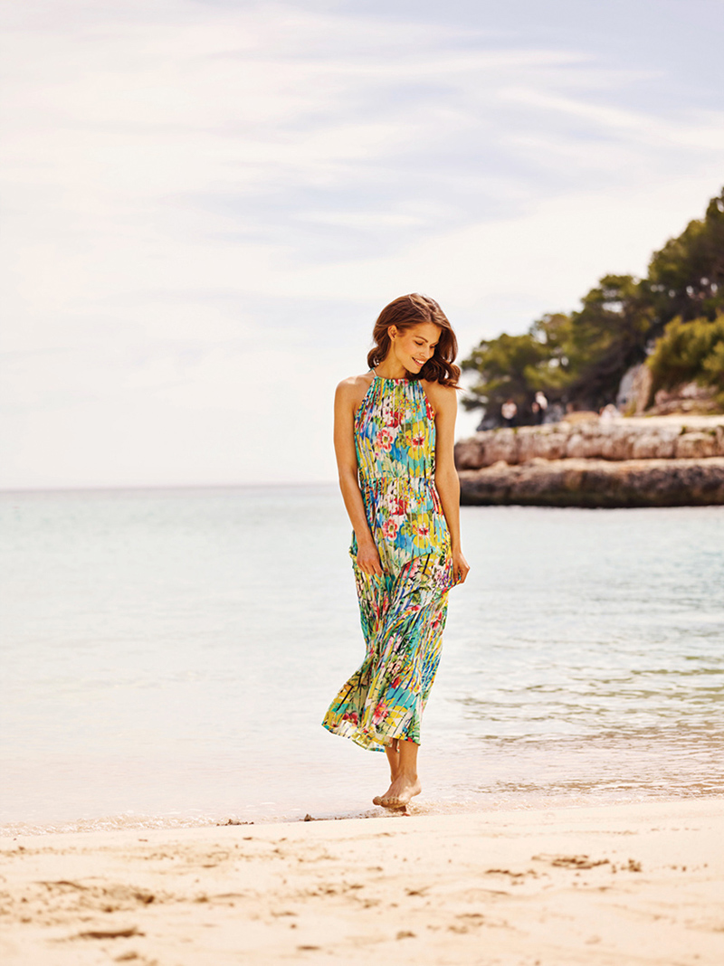 Blooming with color, a floral-print maxi dress from RÖSCH is made of easy-care viscose with the illusion of plissé. Elastic waist and tie-closure at back of neck adds additional style and comfort. 